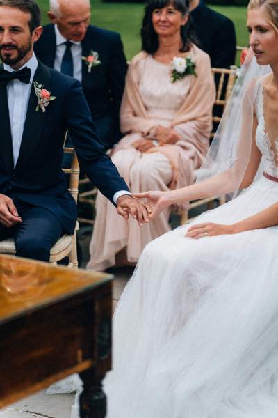 Bride and groom hold hands during wedding ceremony