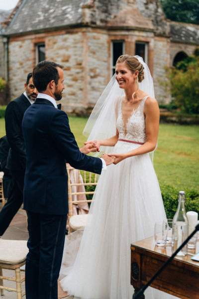 Bride and groom holding hands during ceremony