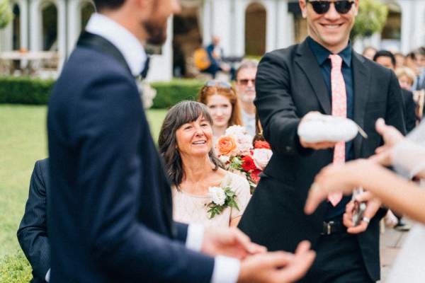 Groomsman and groom at alter in front of guests