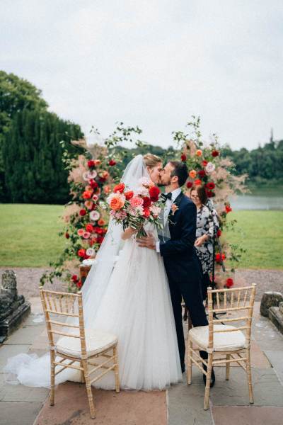 Bride and groom kiss at the alter at wedding ceremony