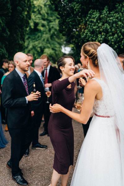 Guests hug bride