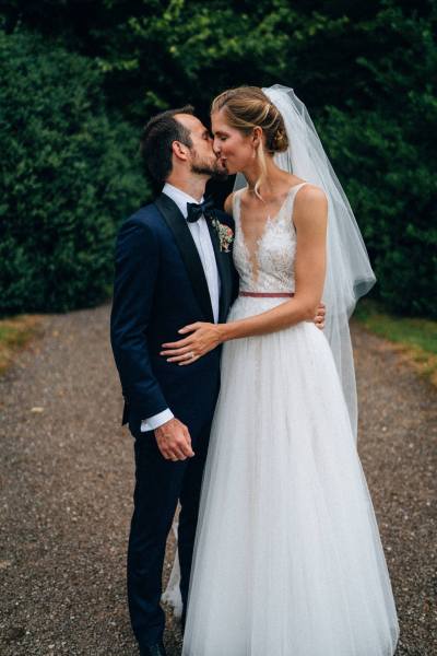 Bride and groom kiss on the pathway