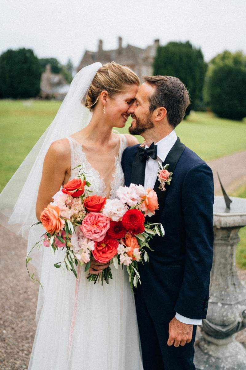 Bride and groom touch foreheads smiling at each other