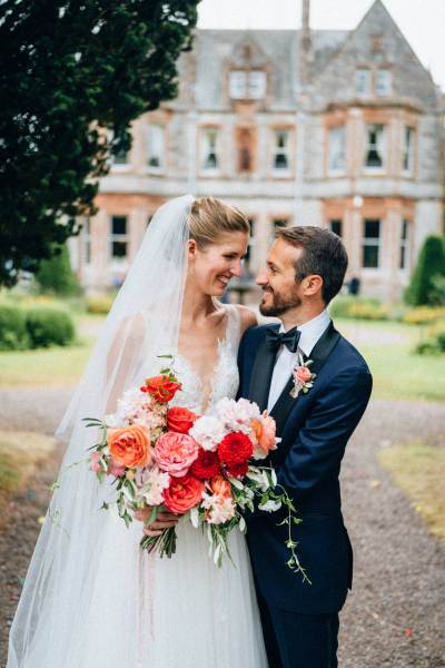 Bride and groom hug and embrace outside wedding venue