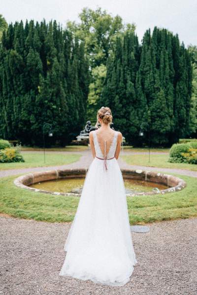 Bride in the garden in front of fountain