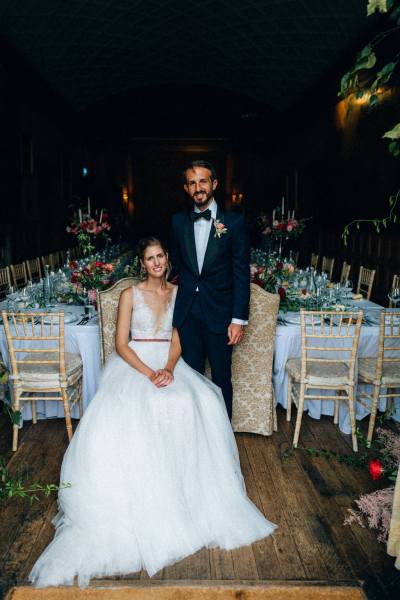 Bride and groom pose interior ballroom/dining room setting