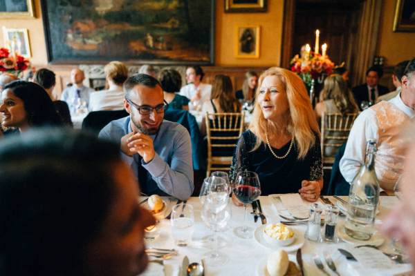 Guests talk and smile at dining room table