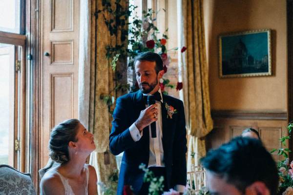 Groom gives speech as he looks at bride