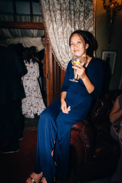 Woman holds glass of gin up and smiles