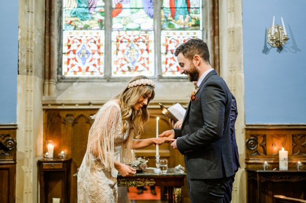 Bride and groom laugh as they exchange wedding bands rings