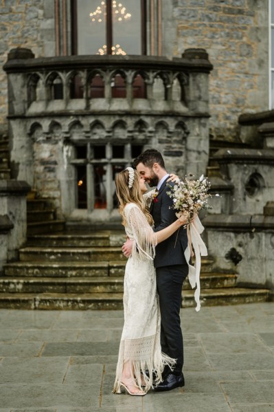 Bride and groom kiss outside wedding venue