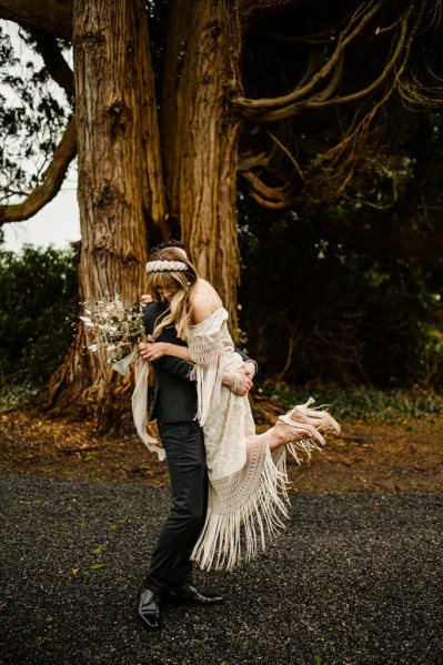 Groom picks up bride in forest setting