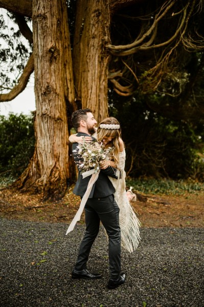 Groom picks up bride in forest setting