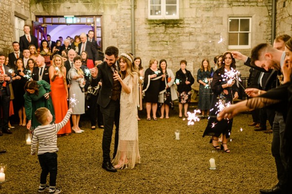 Bride and groom on the grass in front of guests