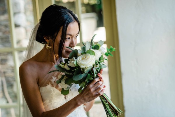 Bride smells the bouquet white roses