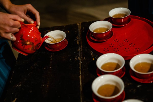 Tea is poured from red teapot and coffee