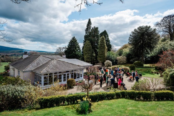 Atmosphere shot with guests outside wedding venue