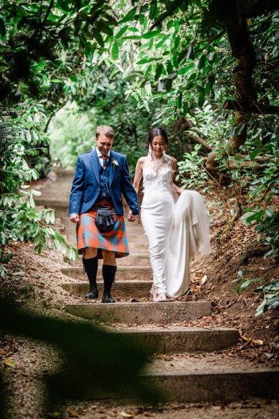 Bride and groom talk hand in hand walking down steps