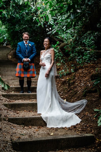 Couple laugh bride and groom stand on steps