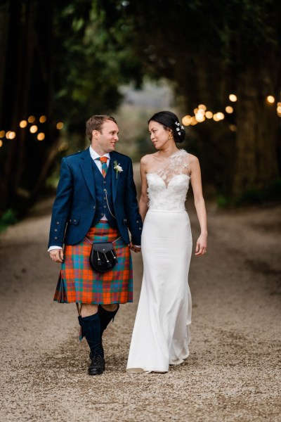 Couple bride and groom walk hand in hand smiling