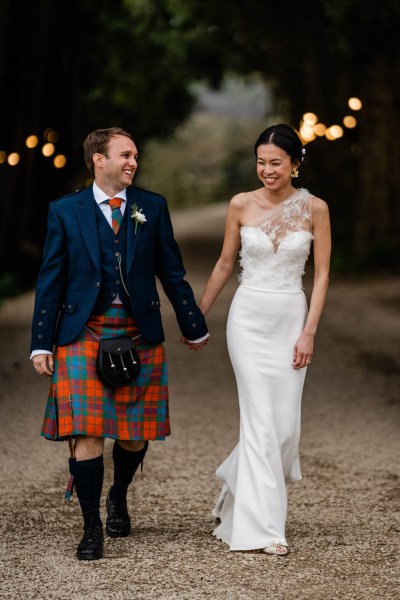 Couple bride and groom walk hand in hand smiling