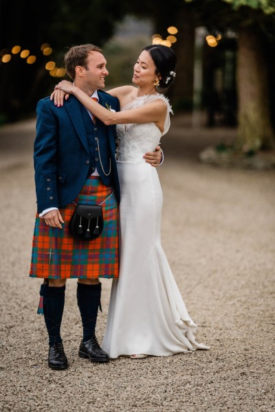 Bride wraps her arms around grooms neck they look at each other