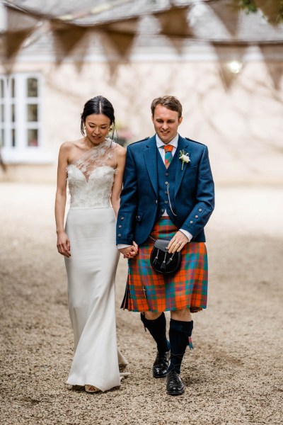 Bride and groom walk hand in hand together