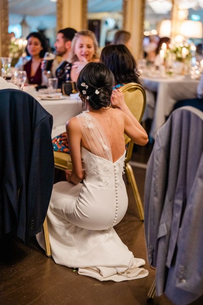 Bride hunkers down hides behind chair