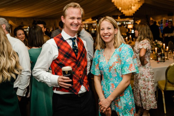 Man holding Guinness poses with woman in blue dress