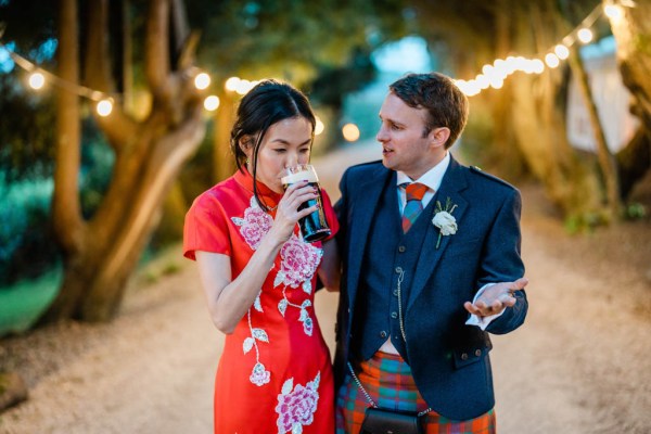 Groom looks at bride as she steals his Guinness