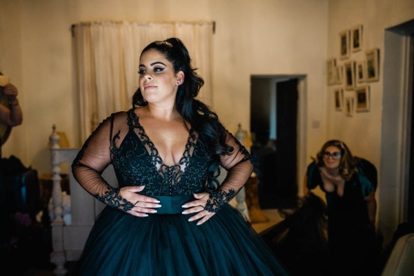 Bride poses in dark blue black bridal gown