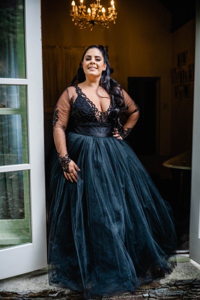 Bride poses in dark blue black bridal gown