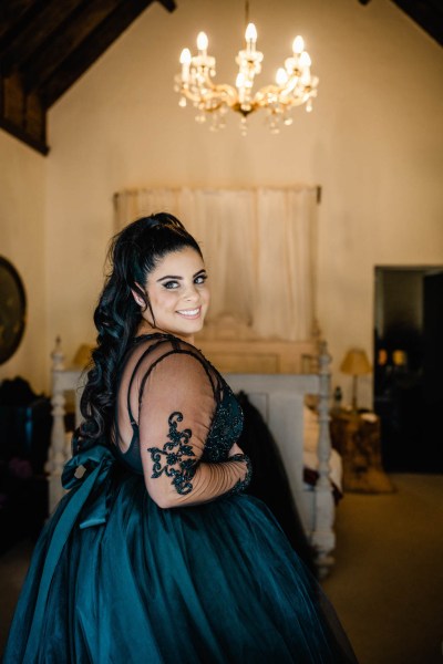 Bride poses over the shoulder holding dress