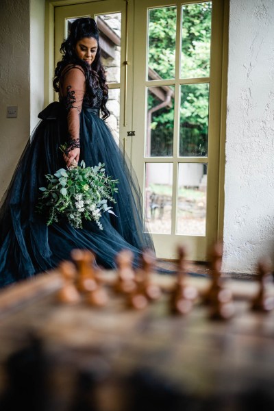 Bride holding bouquet at window