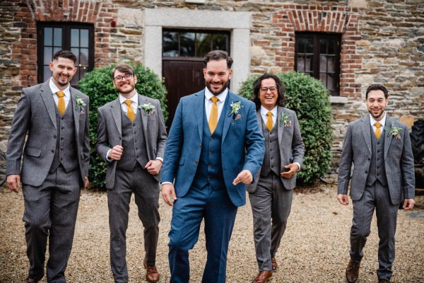 Groom and groomsmen walk along pathway