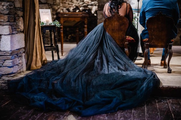 Long black dress belonging to bride and groom sit