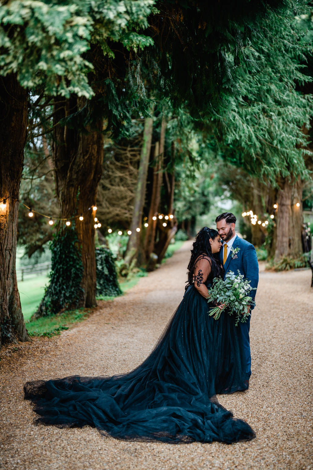 Bride and groom embrace in garden park setting with bouquet flowers