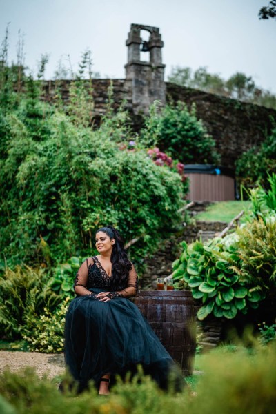 Bride sits in the middle of park garden pathway setting