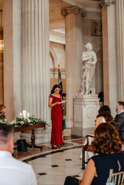 Woman in red officiant gives speech