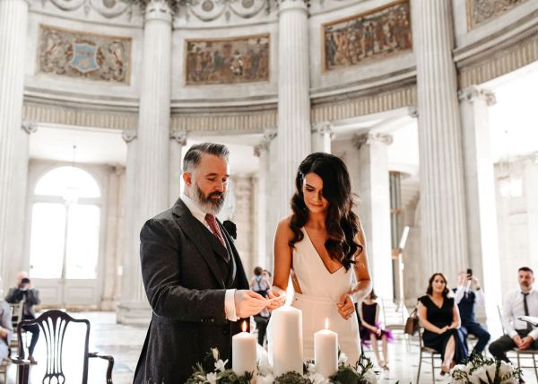 Bride and groom light the candles together at alter