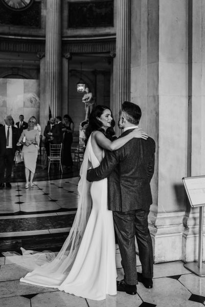 Black and white image of bride and groom hugging embracing