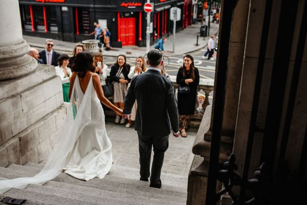 Exterior shot bride and groom and guests walking down the steps