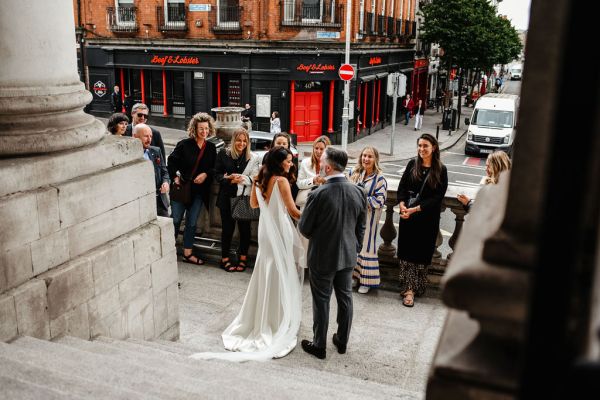 Exterior shot bride and groom and guests