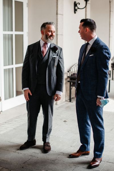 Groom and groomsman smile laughing