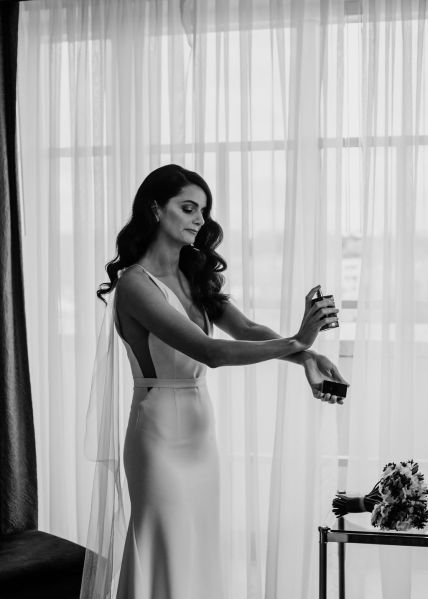 Black and white bride putting on perfume