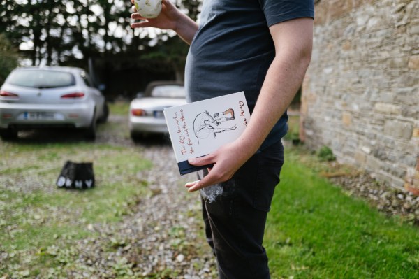 Man holding card in garden and tea