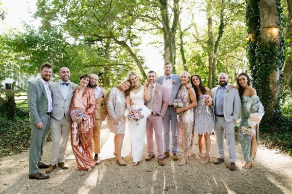 Bride and bridesmaids colourful dresses in forest park setting with groom and groomsmen