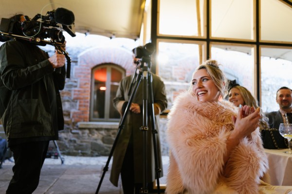 Cameraman behind bride laughing smiling