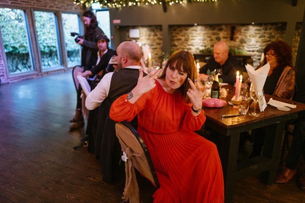 Woman in red gestures to the camera