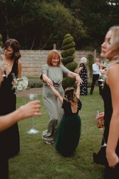 Woman dancing with little girl on grass